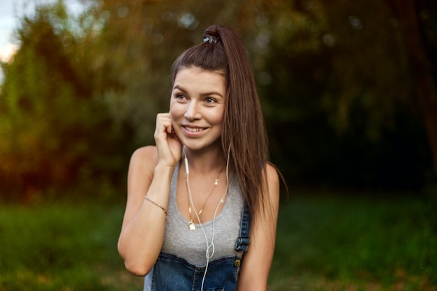 Portrait d'une jeune fille au casque. Sport et mode de vie sain, jogging dans la rue. Cheveux longs et sains