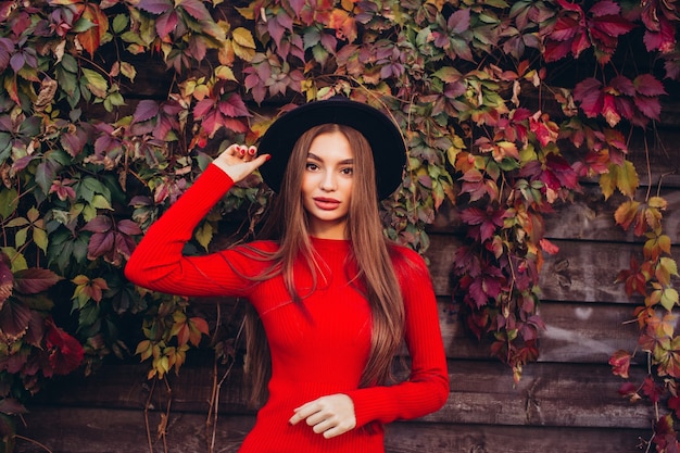 Portrait d'une jeune fille au chapeau noir et robe rouge