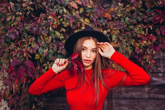 Portrait d'une jeune fille au chapeau noir et robe rouge