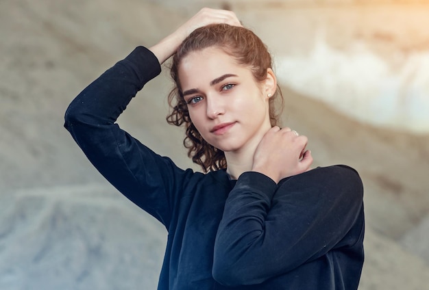 Portrait de jeune fille aux cheveux bouclés lève les cheveux avec ses mains dessus