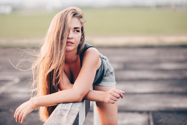 Portrait d'une jeune fille aux cheveux longs un soir d'été se reposant après une séance d'entraînement