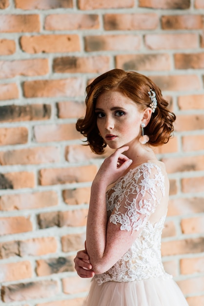 Portrait de jeune fille aux cheveux rouges portant une robe de mariée