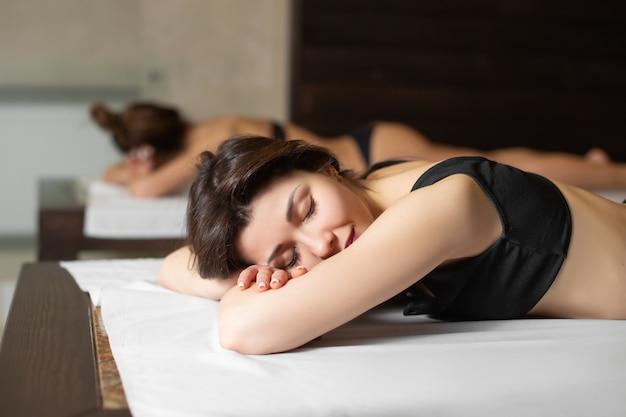 Portrait de jeune fille beau modèle sur des chaises en bois se détendre dans un sauna