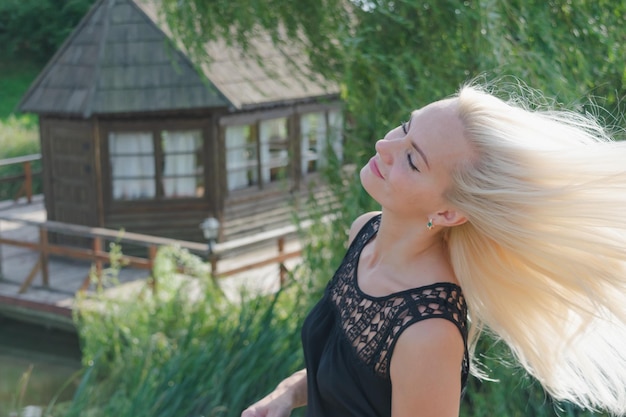 Portrait d'une jeune fille blonde aux cheveux au vent au coucher du soleil.