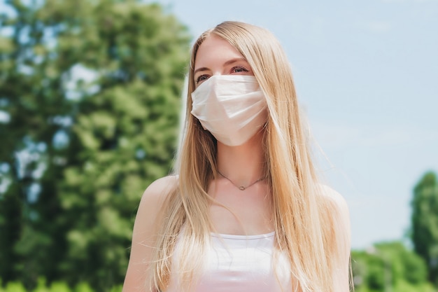 Portrait d'une jeune fille blonde dans un masque médical