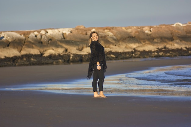 Portrait d'une jeune fille blonde posant à la mer avec des accessoires de mode usés