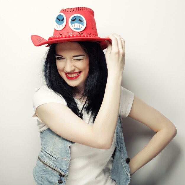 Portrait de jeune fille branchée à chapeau rouge