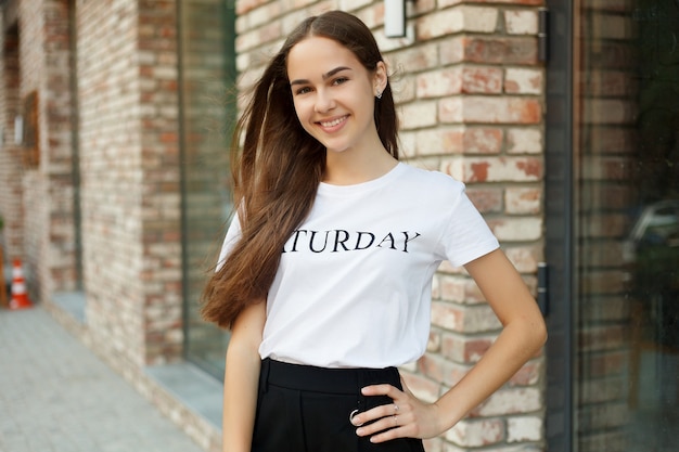 Portrait d'une jeune fille brune dans un t-shirt blanc