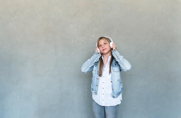 Portrait d'une jeune fille avec un casque sur fond gris