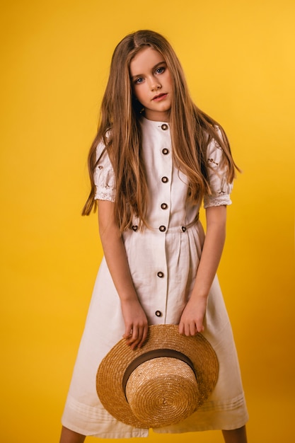 Portrait d'une jeune fille avec un chapeau à la main sur un fond d'été