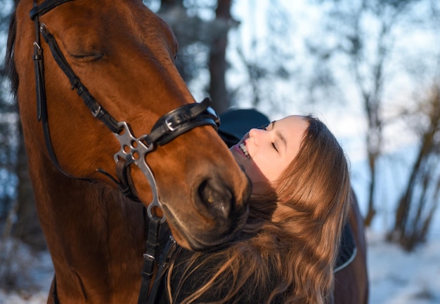 Portrait d'une jeune fille avec un cheval en hiver.