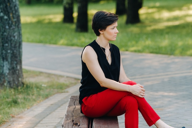 Portrait d'une jeune fille en costume rouge debout dans l'allée du parc