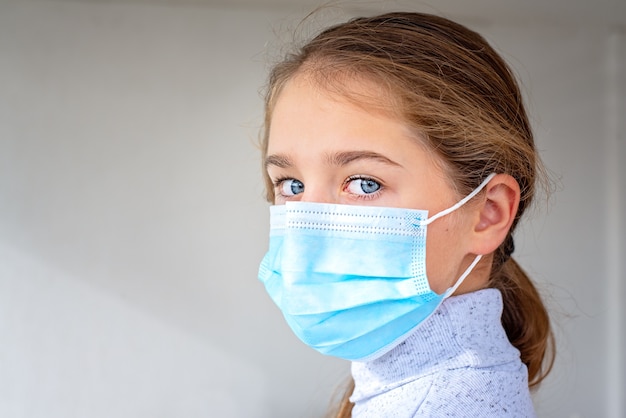 Photo portrait d'une jeune fille dans un gros plan de masque médical.