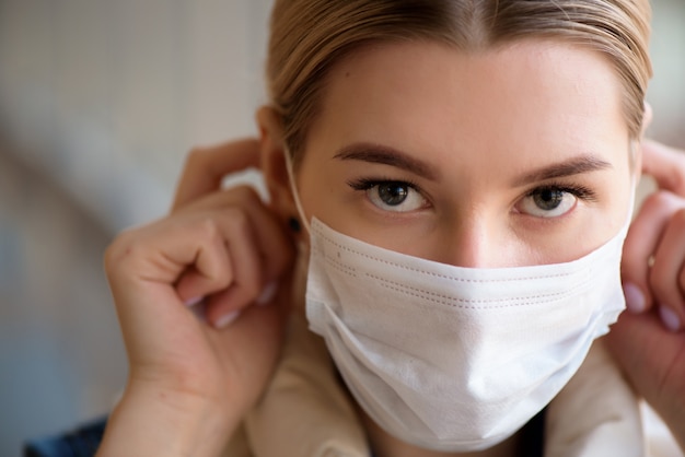 Portrait d'une jeune fille dans un masque de protection sur son visage. Le concept de maladie infectieuse, coronavirus