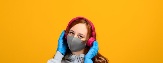 Portrait d'une jeune fille dans un masque, qui met un gant en caoutchouc.