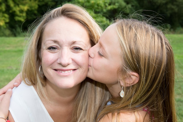 Portrait de jeune fille donnant un baiser à sa maman