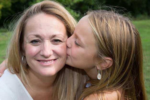 Portrait de jeune fille donnant un baiser à sa maman