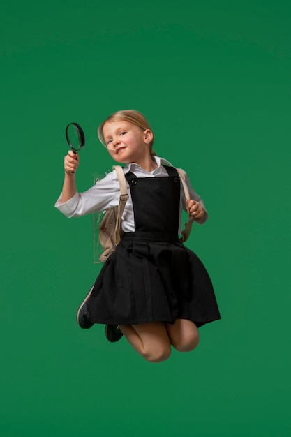 Portrait de jeune fille étudiante en uniforme scolaire sautant en l'air