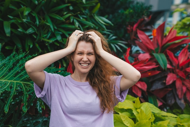 Portrait de jeune fille sur un fond naturel vert femme respectueuse de l'environnement dans un parc tropical ou une dame positive de la jungle aime marcher le jour d'été