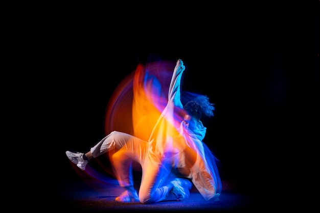 Portrait de jeune fille, formation de danseuse hip-hop isolée sur fond noir en néon. Lumières mixtes