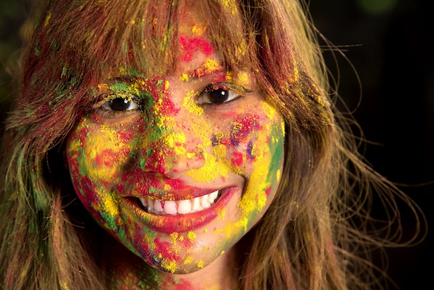 Portrait d'une jeune fille heureuse sur le festival des couleurs Holi