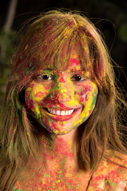 Portrait d'une jeune fille heureuse sur le festival des couleurs Holi