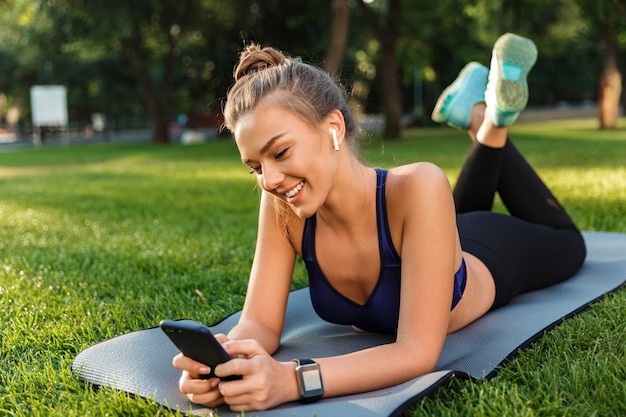 Portrait d'une jeune fille heureuse de remise en forme portant sur un tapis