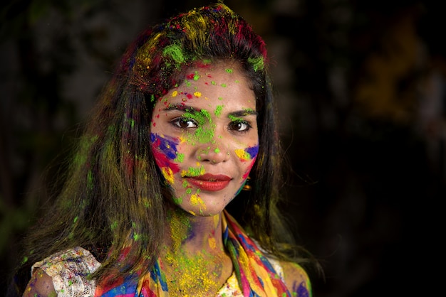 Portrait d'une jeune fille heureuse avec un visage coloré à l'occasion du festival des couleurs Holi.