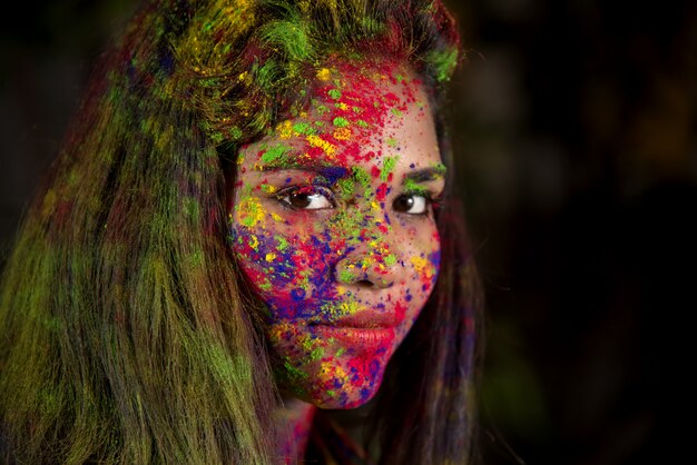 Portrait d'une jeune fille heureuse avec un visage coloré à l'occasion du festival des couleurs Holi.