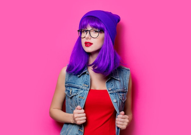 Portrait de jeune fille hipster de style aux cheveux violets sur fond rose