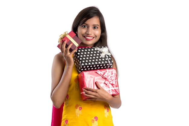 Portrait de jeune fille indienne souriante heureuse tenant des coffrets cadeaux sur un blanc.