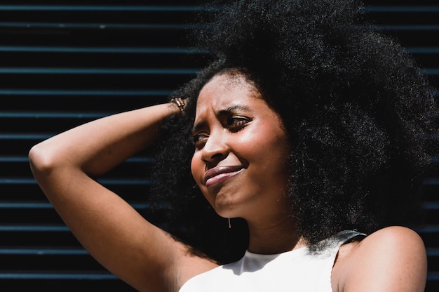 Photo portrait de jeune fille latine brune avec afro regardant sur le côté avec un visage confus