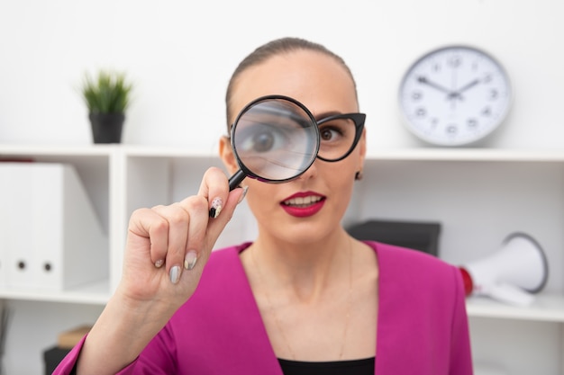 Portrait d'une jeune fille avec une loupe. Étudier les informations