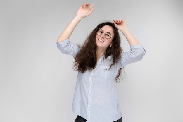 Portrait d'une jeune fille à lunettes. Belle jeune fille sur fond gris