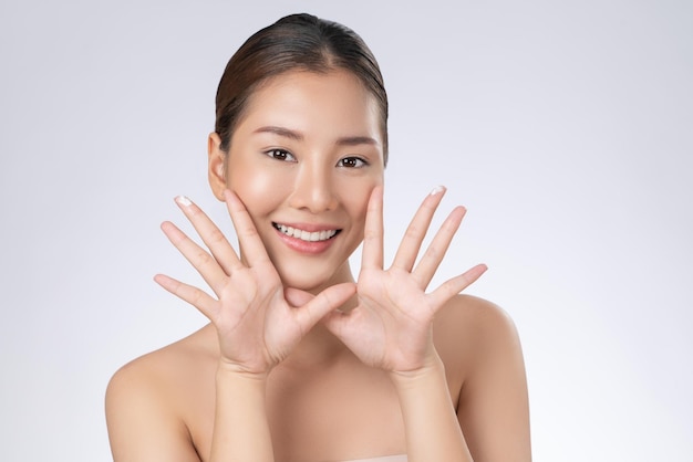 Portrait d'une jeune fille magnifique posant un geste de beauté avec une peau fraîche et propre