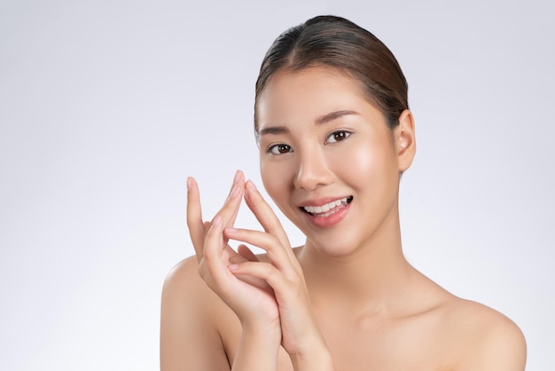 Portrait d'une jeune fille magnifique posant un geste de beauté avec une peau fraîche et propre