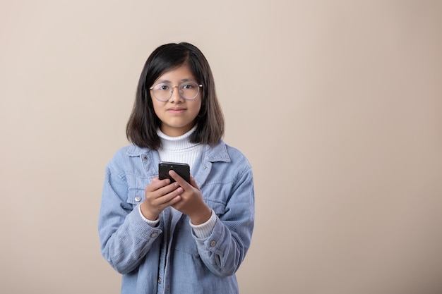 Portrait de jeune fille mexicaine avec téléphone intelligent et lunettes