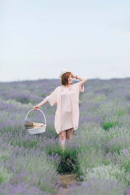 Portrait d'une jeune fille mignonne dans une robe rose dans un champ de lavande