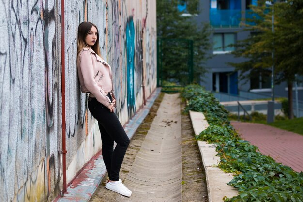 Portrait de jeune fille à la mode sur le mur de graffitis