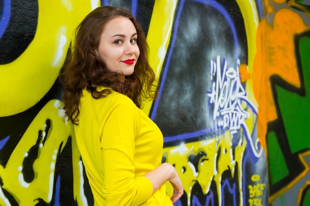 Portrait de jeune fille à la mode sur le mur de graffitis