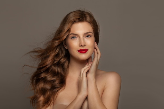 Portrait de jeune fille modèle rousse élégante. Belle femme aux longs cheveux bouclés