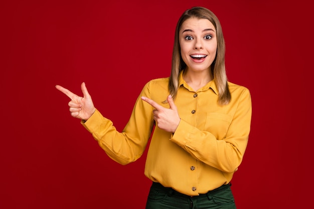 Portrait de jeune fille montrant un nouvel espace de copie de nouveauté isolé sur fond de couleur rouge vif éclat