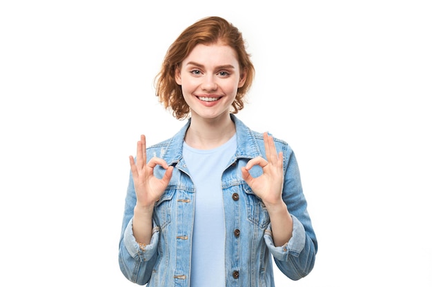 Portrait de jeune fille montrant signe OK avec les doigts isolé sur fond blanc Carrière réussie concept accepté