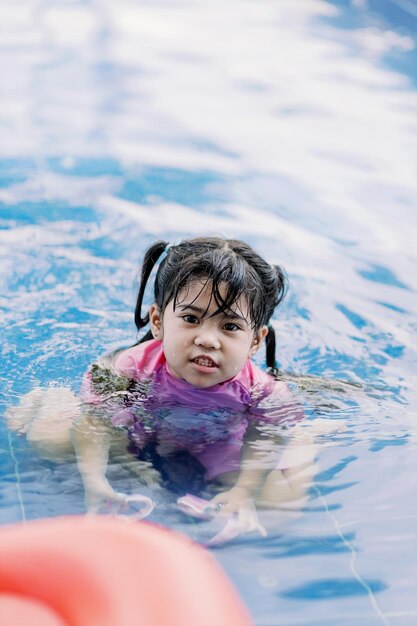 Portrait d'une jeune fille nageant dans une piscine