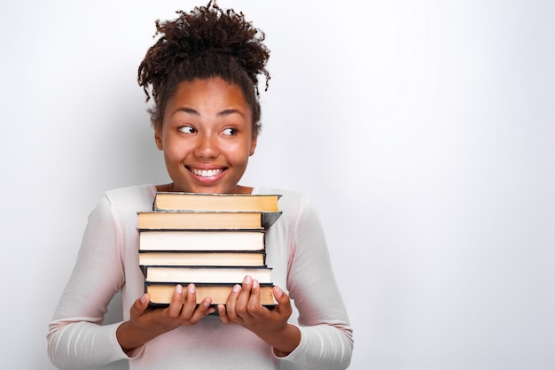 Portrait de jeune fille nerd heureux tenant des livres sur blanc. Retour à l&#39;école