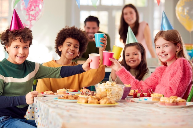 Portrait de jeune fille avec des parents et des amis à la maison célébrant l'anniversaire avec la fête