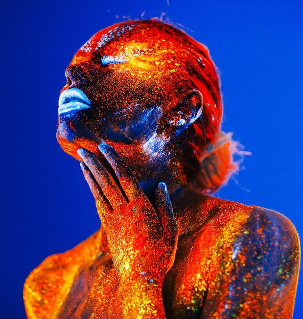 Portrait d'une jeune fille peinte en poudre fluorescente.