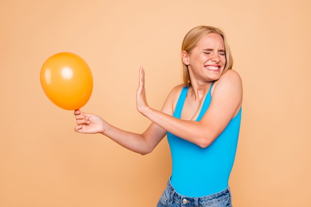 Portrait de jeune fille peur du ballon d'hélium air isolé sur beige