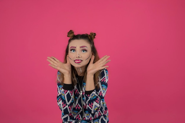 Portrait de jeune fille portant un maquillage fantaisie coloré et souriant à la caméra. Photo de haute qualité