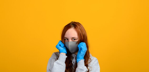 Portrait d'une jeune fille portant un masque facial sur fond jaune